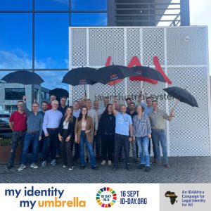 Employees of IAI Industrial Systems holding branded umbrellas outside the company headquarters in support of the ID Day campaign promoting legal identity awareness.